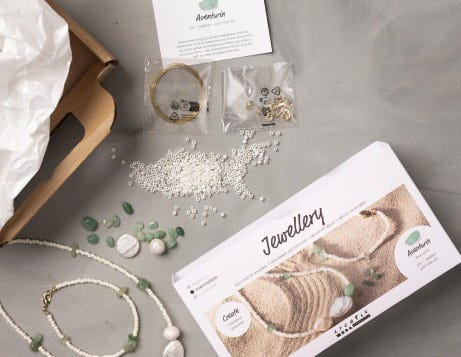 Se abrieron kits de bricolaje de joyería y se muestra su contenido sobre una mesa