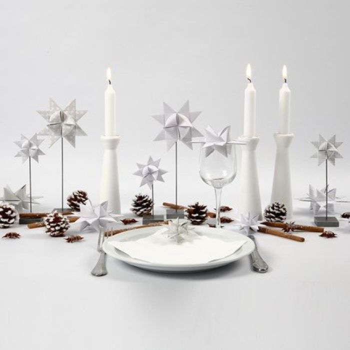 Estrellas de ropa en base, candelabro de madera y piñas