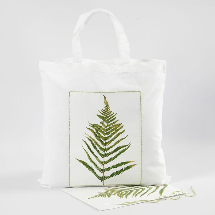 Una bolsa de compras con un diseño de hoja y un borde bordado