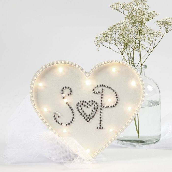  Una caja de luz en forma de corazón decorada con pedrería y perlas