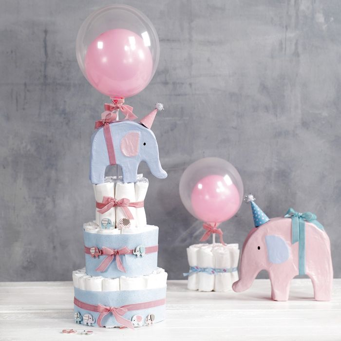 Un pastel de pañales con elefantes y globos