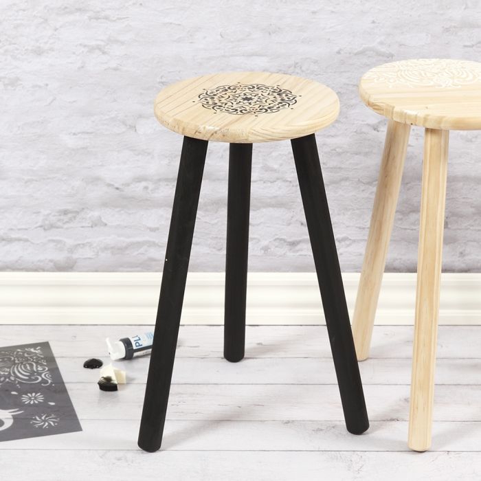 Un taburete de madera decorado con modelos étnicos usando una plantilla
