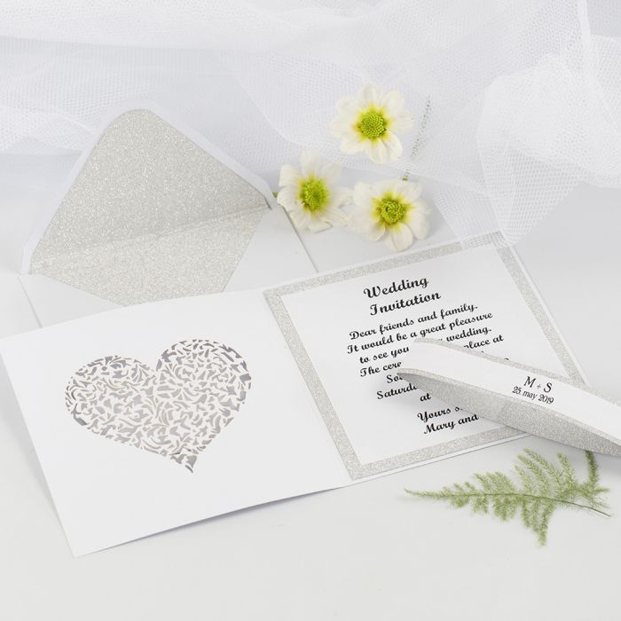 Una invitación de boda y un sobre decorado con papel decorado 