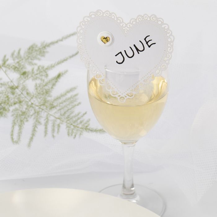 Una tarjeta para lugar de boda en forma de corazón con una pegatina hinchada.  
