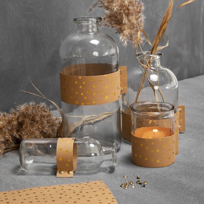 Botellas de vidrio y candelabros decorados con papel de imitación al cuero