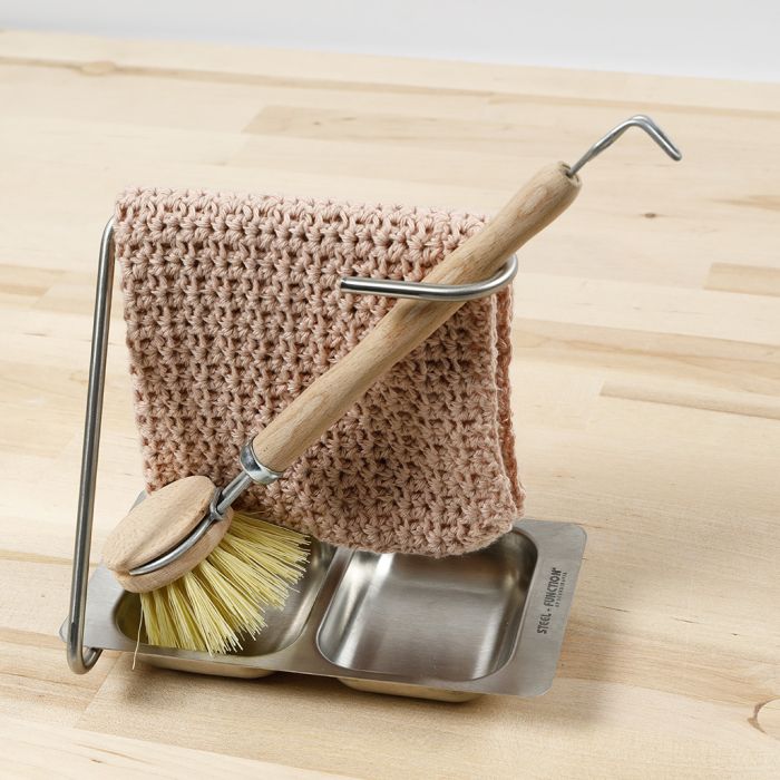 Un paño de cocina tejido a ganchillo con un patrón de estilo de puntada de concha
