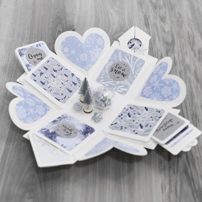 Una caja de explosión decorada con papel de diseño y un país de las maravillas de invierno