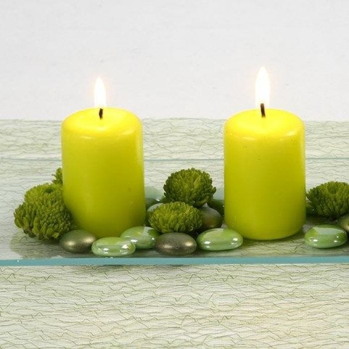 Velas color lima y decoración de cristal en un plato