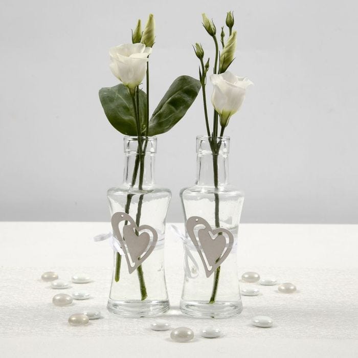 Jarrón de cristal con corazón de madera atado con cinta satinada