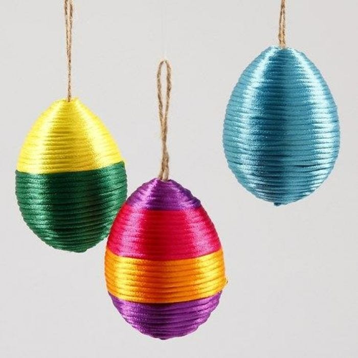 Papier-mâché Easter eggs wound round with satin cord