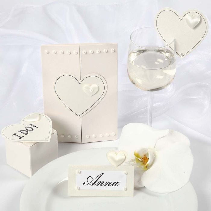 Corazones satinados sobre invitaciones y decoraciones de boda