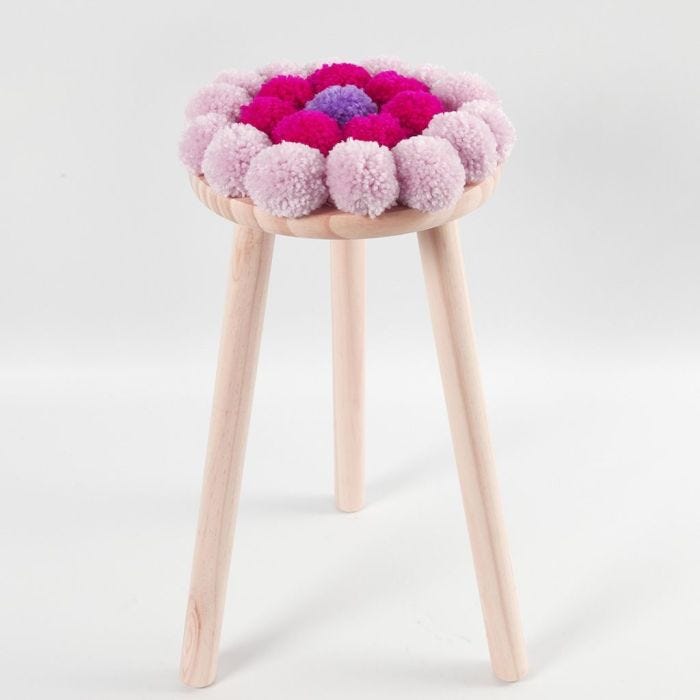 Un cojín con Pom-poms para un taburete