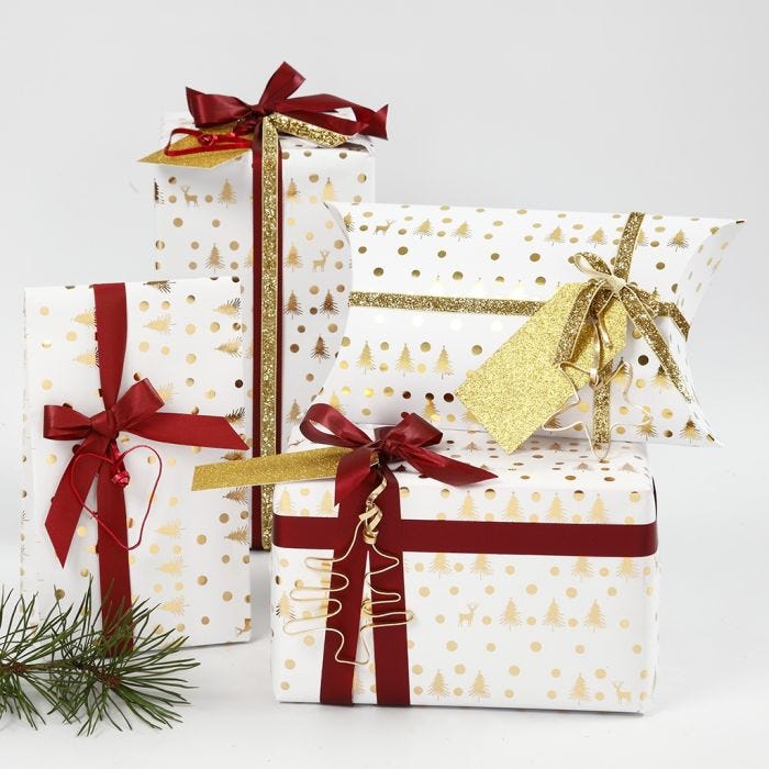 Envoltorio de regalo de Navidad blanco y dorado decorado con formas de alambre y cinta