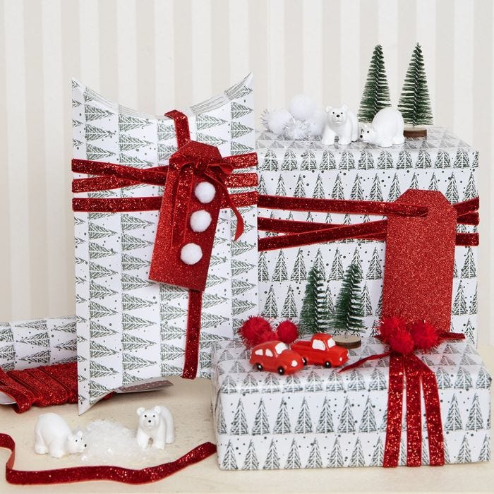 Papel de regalo navideño decorado con pompones y figuras en miniatura