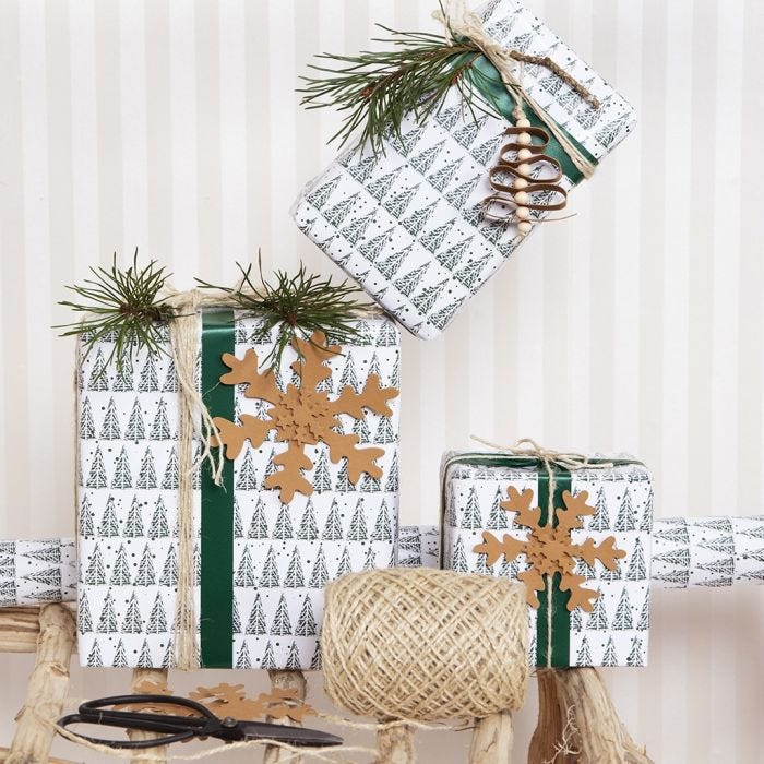 Envoltorio de regalos de Navidad con un adorno de árbol de Navidad y decoraciones de papel de imitación piel