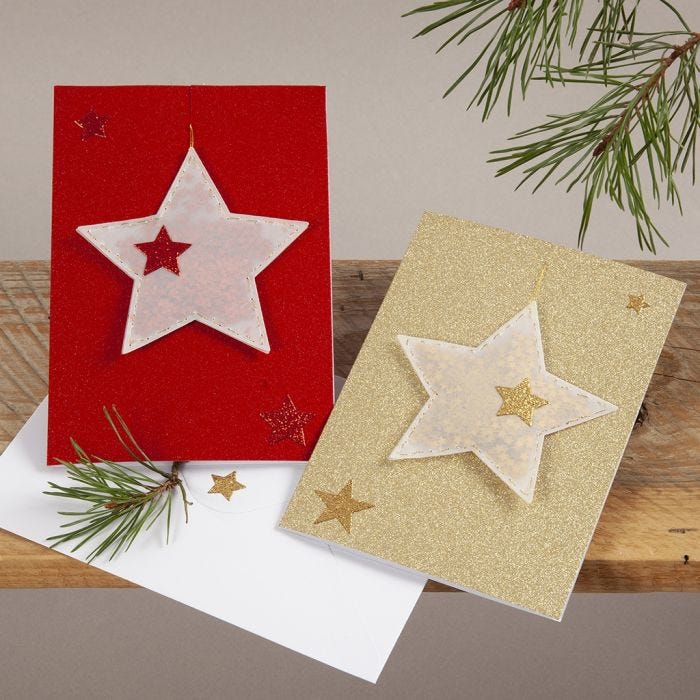 Tarjetas de Navidad brillantes con estrellas de vellum colgantes.