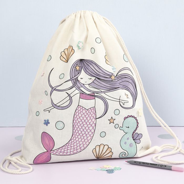 Una bolsa de cordón con un diseño de sirena preimpreso decorado con rotuladores textiles y lentejuelas