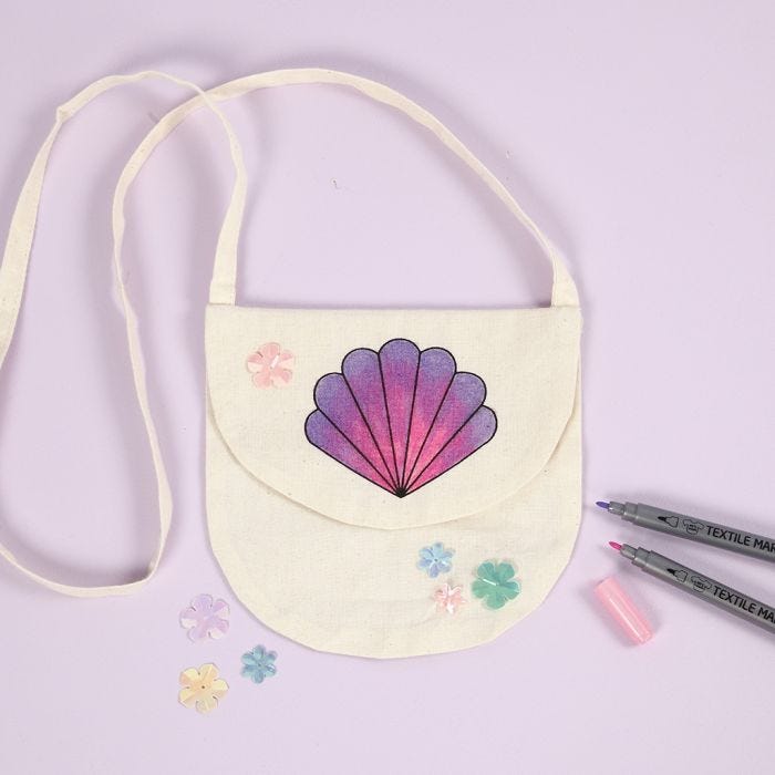 Un bolso de mano con un diseño de concha decorado con rotuladores textiles