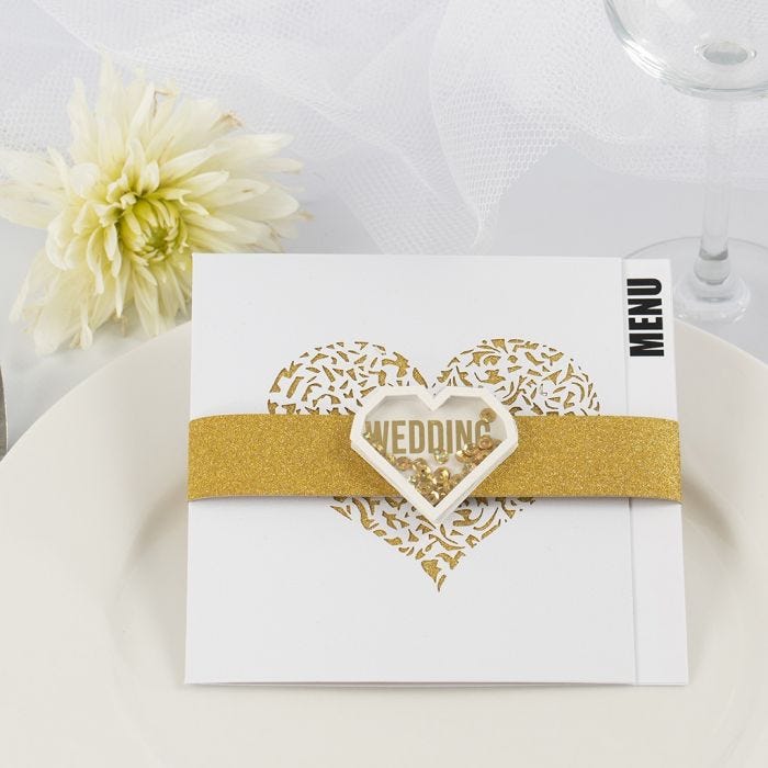 Una tarjeta para menú de boda con papel de diseño brillante dorado y una pegatina shaker.