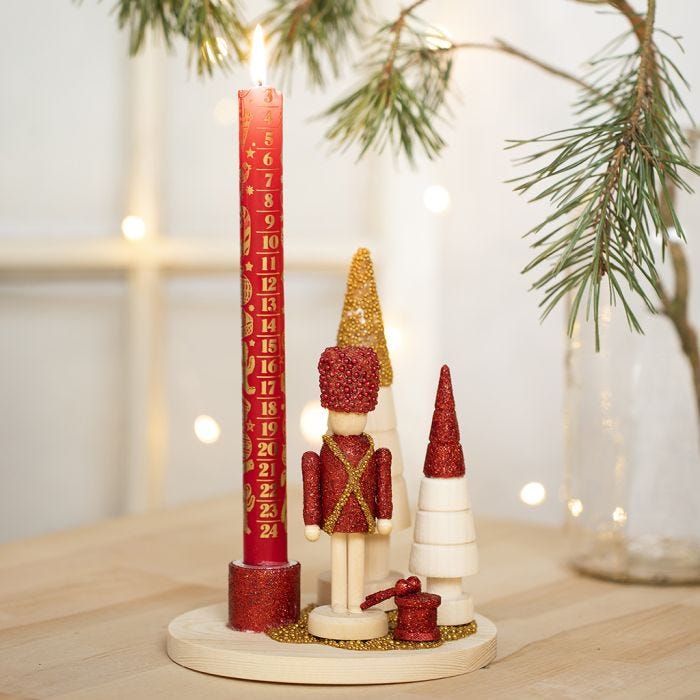 Un candelabro decorado con una figura de cascanueces, árboles de navidad y mini cuentas de vidrio