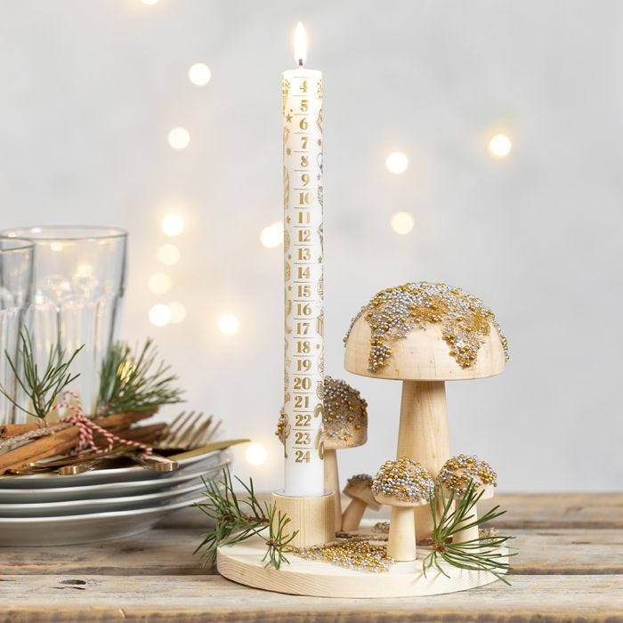 Un candelabro en una base de madera con setas decoradas con cuentas de vidrio minis.