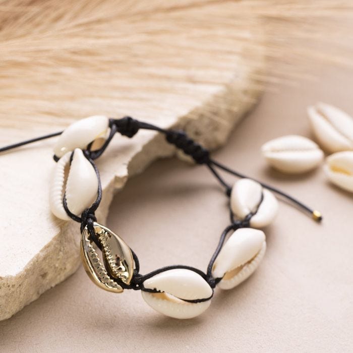 Una pulsera trenzada o pulsera de tobillo con conchas marinas