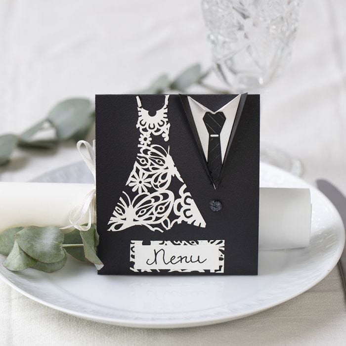 A menu card for a wedding  decorated with a dress and dinner jacket