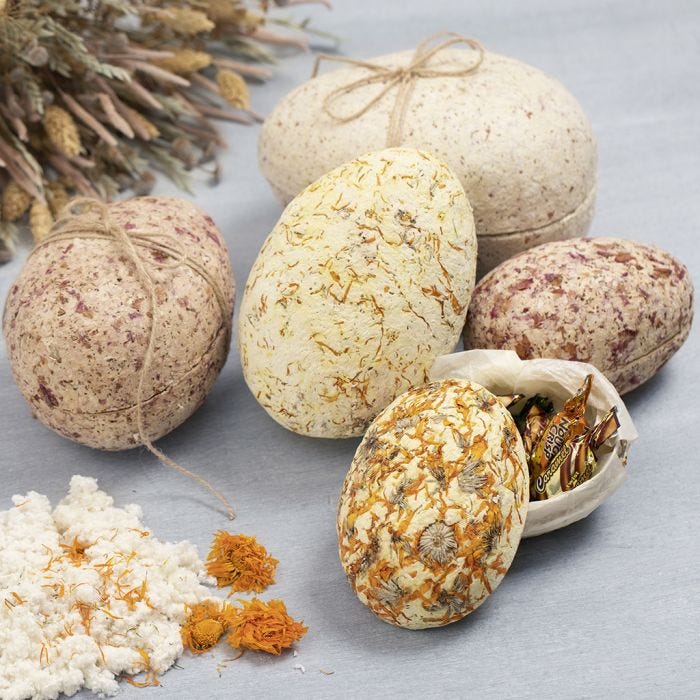 Two-part papier-mâché Easter eggs covered with pulp and dried flowers