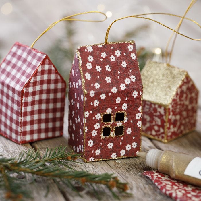 Una tarjeta y tela casa de Navidad decorada con brillo para colgando