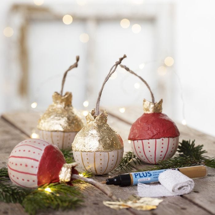 Una bola de Navidad de madera con hoja de metal de imitación de oro