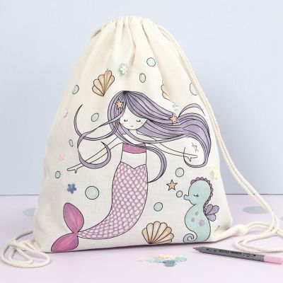 Una bolsa de cordón con un diseño de sirena preimpreso decorado con rotuladores textiles y lentejuelas