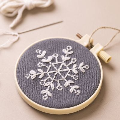 Bastidor de bordado con copo de nieve bordado