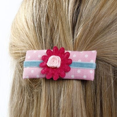 Un pasador hecho de cartulina decorada con tela