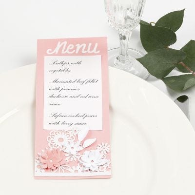 Carta de menú con encaje de cartulina y flores troqueladas.