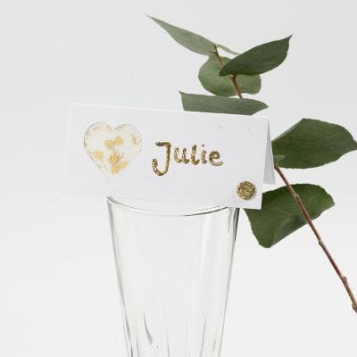 Una tarjeta de lugar decorada con un corazón de papel vellum