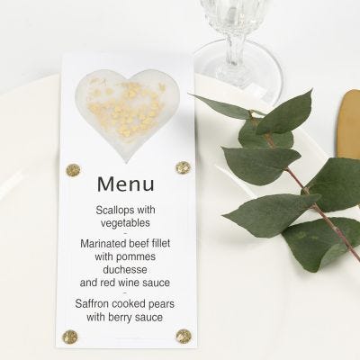 Una carta de menú decorada con un corazón de papel vellum