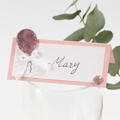 Una tarjeta de lugar con un globo decorado con papel Deco Foil