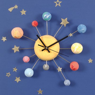 Un reloj de pared decorado con planetas de Silk Clay