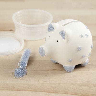 Una hucha de cerdito decorada con cuentas de semilla de rocaille y base adhesiva