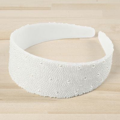 Una cinta de pelo decorada con mini perlas de cristal y medio perlas