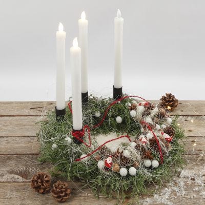 Una corona de Adviento decorada con materiales naturales y velas LED