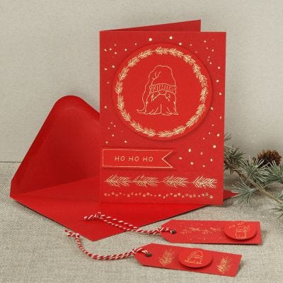 Una tarjeta de Navidad con un duende curioso hecho con foil