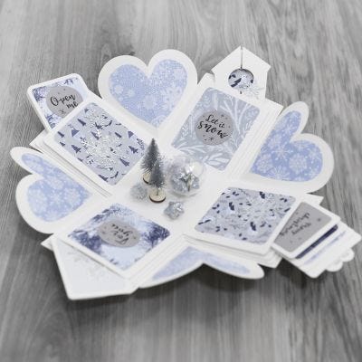Una caja de explosión decorada con papel de diseño y un país de las maravillas de invierno