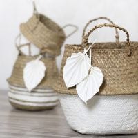 A sea grass basket decorated with craft paint and faux leather paper leaves